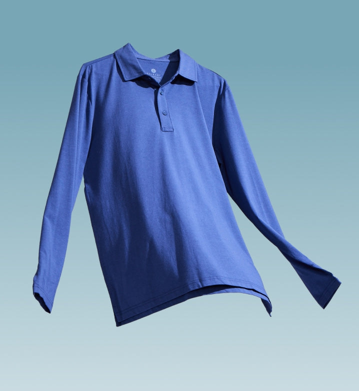 A long sleeve polo shirt floating on a light blue background.